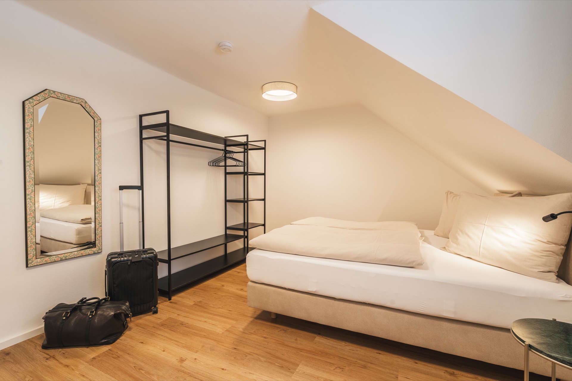 Helles Schlafzimmer mit charmantem Dachschrägen-Charakter und modernem offenem Kleiderschrank im Appartement Nr.16 Landhaus Prägant Bad Kleinkirchheim – gemütlich und stilvoll, Ferienwohnung Fotografie Kärnten